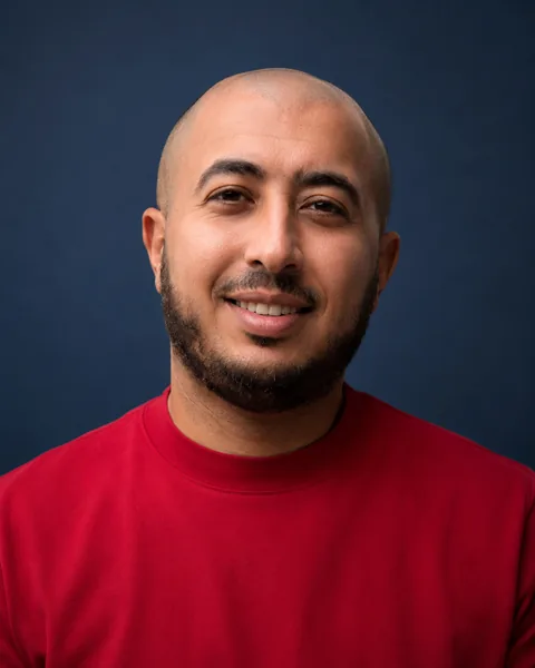 Islam Magdy, smiling, in a studio portrait.